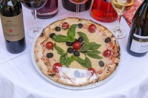 Pizza Margherita mit Tomaten, Oliven und Basilikum