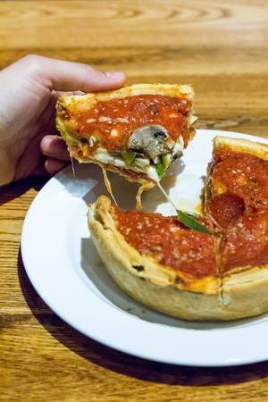 Pizza nach Chicagoer Art mit Salamiwurst und Pilzen