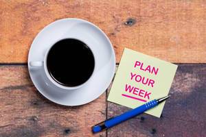 Plan your week - Plane deine Woche auf einer Notiz mit einer Tasse Kaffee