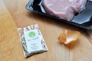 Plastic bag with oregano, next to onionskin and turkey breast