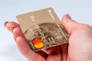 Plastic card in women hand on white background