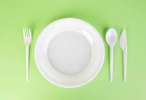 Plastic dishes on green background