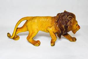 Plastic male lion toy on white surface