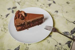 Plate with slice of tasty homemade chocolate cake_top view