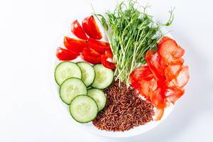 Plate with slices of tomato, cucumber, pickled ginger, brown rice and micro-green peas. Top view (Flip 2019)