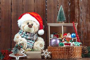 Plüschbär mit Weihnachtsmannmütze und Festtagdekorationen