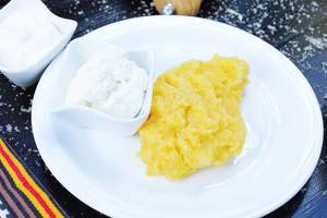 Polenta with cream on a white plate. Balkan traditional recipe (Flip 2019)