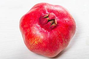 Pomegranate fruit on a white wooden background (Flip 2019)
