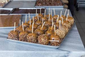 Popular at Halloween: caramel apples or taffy apples with peanuts applied, on display at historic Kilwins chocolate store in Chicago