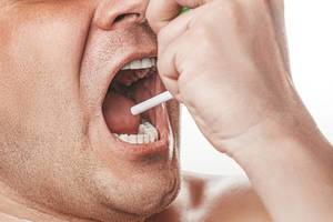 Portrait of a sick man sprays therapeutic aerosol in the oral cavity (Flip 2019)