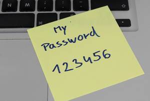 Post it with "My password 123456" on a notebook symbolising weak data security