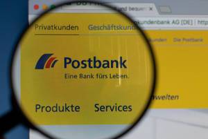 Postbank-Logo am PC-Monitor, durch eine Lupe fotografiert