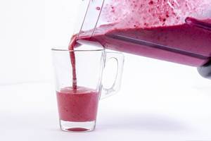 Pouring Raspberry Banana and Blackberry Smoothie in the glass