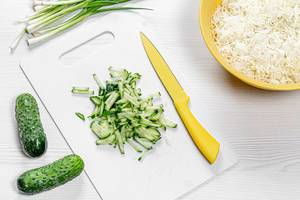 Preparation and cutting of ingredients for salad with cucumber and cabbage