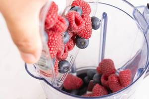 Preparing smoothie juice of Blueberries and Raspberries