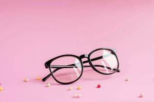 Produktfoto einer Brille vor rosafarbenem Hintergrund