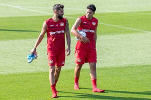 Professional football player Kerem Demirbay and Nadiem Amiri walking barefoot, without shoes, after the football team practice session