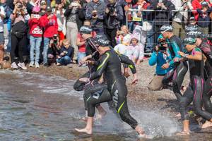 Professionelle Sportlerinnen startet mit der Frauengruppe zum Schwimmwettkampf des Triathlon Ironman 70.3 & rennen in den Vesijärvi-See