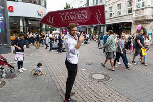 Promoter mit dem Transparent für das Pop-up-Store Die Höhle des Löwen