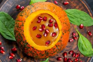 Pumpkin puree with fresh pomegranate seeds and spinach. The view from the top