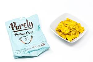 Purely Plantain Chips mit wildem Knoblauch in weißer Schüssel und Verpackung auf weißem Hintergrund