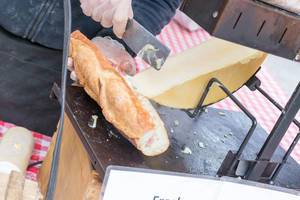 Putting melted raclette cheese in a sandwich - City Market, Chicago