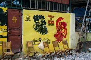 Railway Cafe in Hanoi - nahe der Bahnschienen stehen vier Stühle