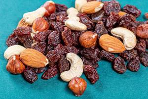 Raisins and different nuts on a green background