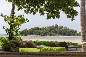 Rattan furniture under tropical trees on Mahé, Seychelles infant of tiny island in the Indian Ocean