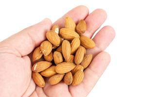 Raw Almonds in the hand above white background