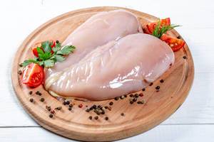 Raw chicken breast fillets with spices on the kitchen Board