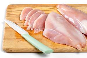 Raw chicken fillet on wooden kitchen board with knife (Flip 2019)