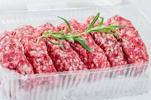 Raw minced meat for cutlets and rosemary branch