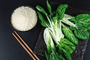 Raw rice and cabbage Pak Choi baby on a black background (Flip 2020)