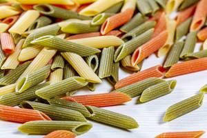 Raw tricolor pasta set on the wooden table