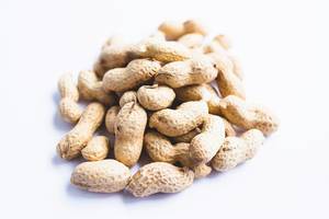 Raw whole peanuts in shell on white background