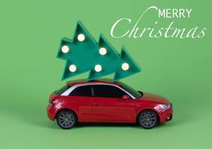 Red Audi A1 carrying a christmas tree