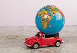 Red beetle car with globe on map