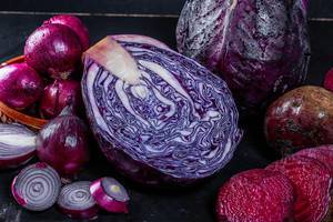 Red cabbage, onions and beets on a dark background