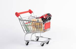 Red car with Euro banknotes in shopping cart