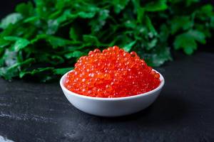 Red caviar with fresh green parsley behind