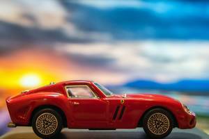 Red Ferrari toy car on platform with sunset background (Flip 2019)