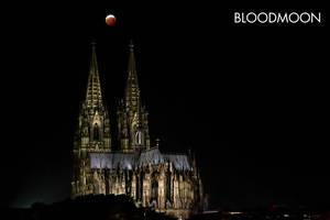 Red Moon over illuminated Cologne Cathedral with picture Title "Bloodmoon"