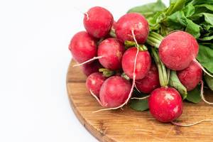 Red Radishes on the wooden board above white background with copy space