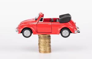 Red toy car on stack of coins