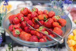 Reife Erdbeeren in einer Glasschale mit einer Salatzange