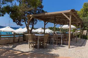Restaurant porch by the sea in Argolis, Greece, with tables under a bast pavilion
