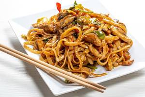 Rice noodles with chicken, mushrooms and vegetables close-up