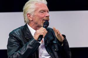 Richard Branson explaining on stage in discussion with Tim Höttges