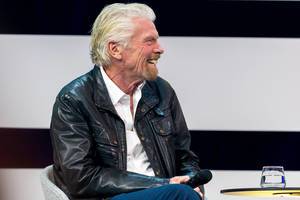 Richard Branson lacht auf der Bühne der Digital X in Köln